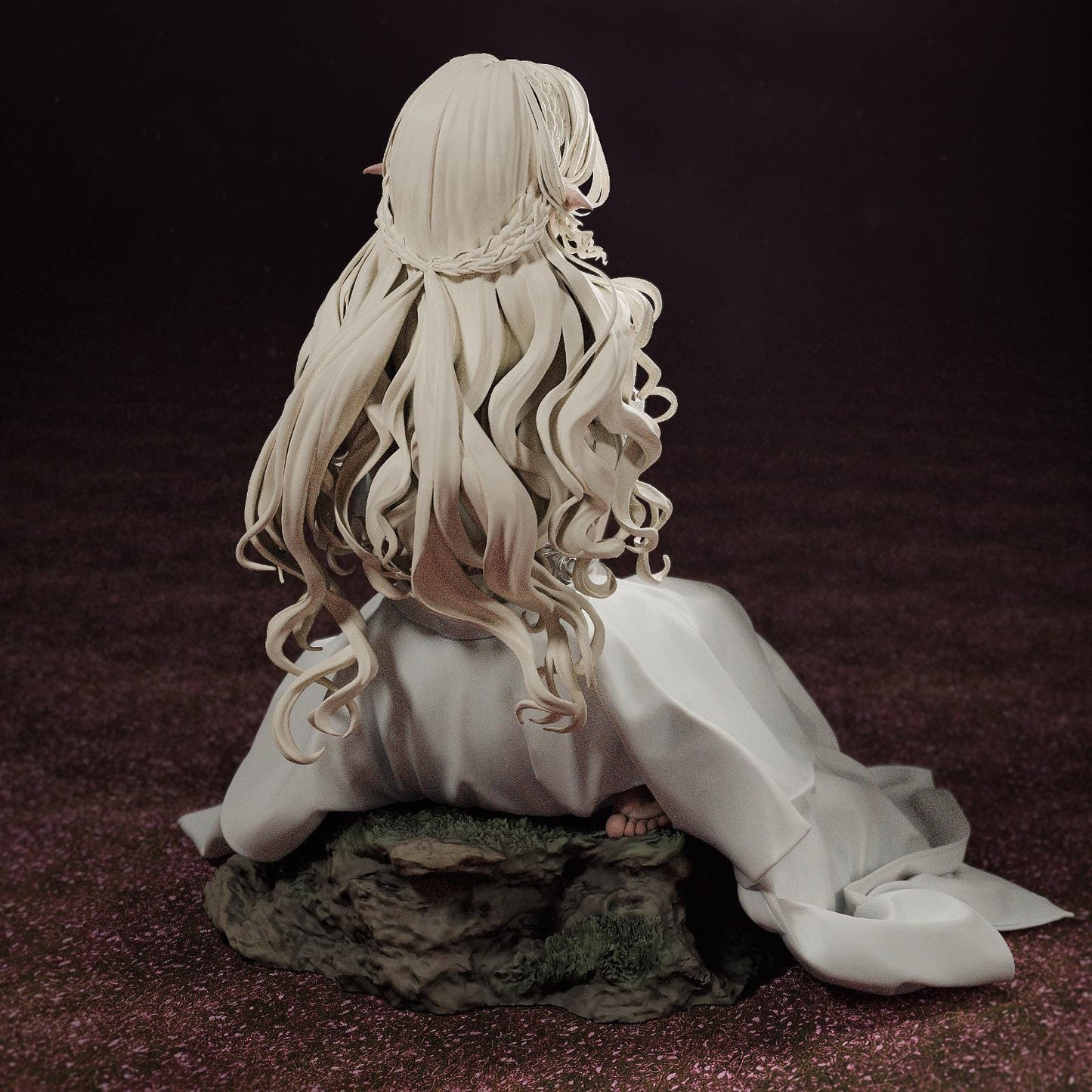 a statue of a woman with long hair sitting on a rock